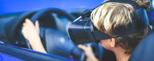 A close-up of a VR headset displaying an interactive advertisement for a car. The user is virtually sitting inside the car, exploring its features with hand gestures.