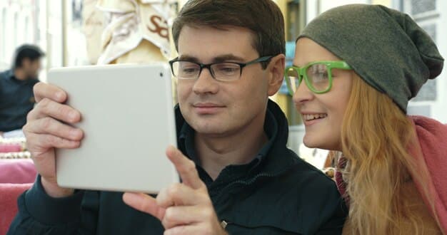 A person using a smartphone app to customize a pair of glasses with different frame styles and lens colors. The AR overlay shows the selected glasses accurately displayed on the person's face in real-time.